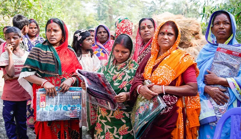 Volunteers from Nabatara Foundation – Save The Soul, the leading pandemic relief NGO Kolkata, handing ration kits, masks and medicines to masked families standing in socially distanced lines in a Kolkata slum during a pandemic lockdown
